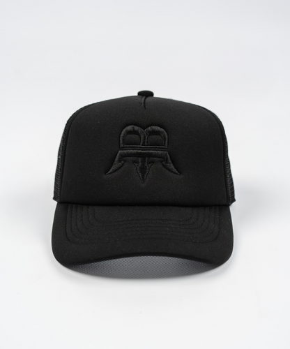 Unisex black trucker cap with a black Born Maniac logo on the front, crafted from durable wool fabric with a breathable mesh panel and an adjustable rear strap for a one-size-fits-all fit.